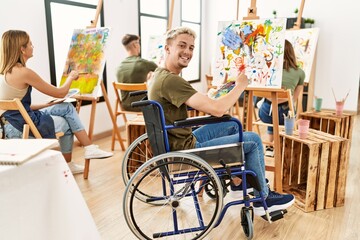 Group of people drawing at art studio. Young man sitting on wheelchair.