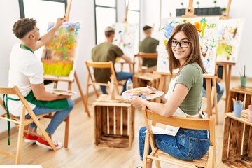Group of people drawing at art studio. Woman smiling happy looking to the camera.