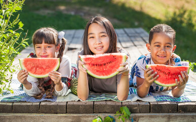 Three children with watermelon slices