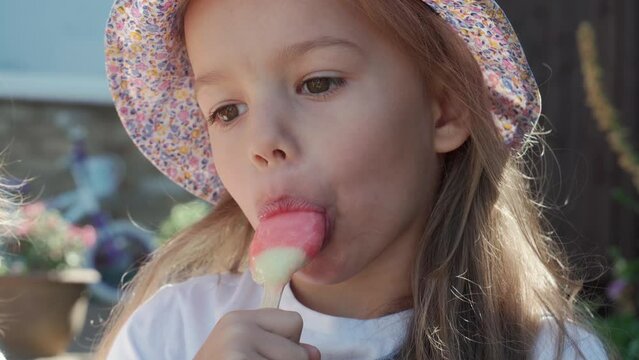 Close up portrait Girl enjoys delicious ice cream cone. Child eating watermelon popsicle. Kid Sibling snack sweets in Home Garden. Summer holiday Hot weather Sunny Day. Childhood, Food Candy Friends