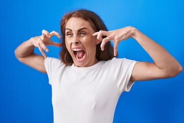 Naklejka premium Young beautiful hispanic woman standing with furious expression over isolated blue background