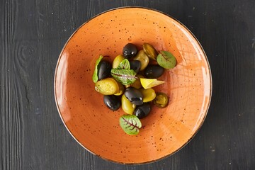 Olives and olives with lemon and salted vegetables. Serving dishes at the restaurant.