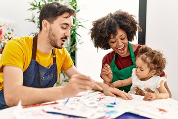 Couple and daughter smiling confident drawing at art studio