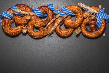 Oktoberfest concept - pretzels with traditional pattern ribbon and ears of wheat