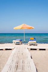 Two sunbed and a parasol on the beachfront