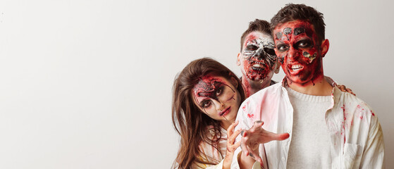 Scary zombies on light background with space for text. Halloween celebration
