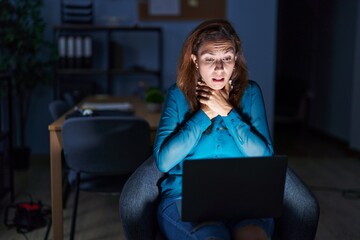 Brunette woman working at the office at night shouting and suffocate because painful strangle. health problem. asphyxiate and suicide concept.