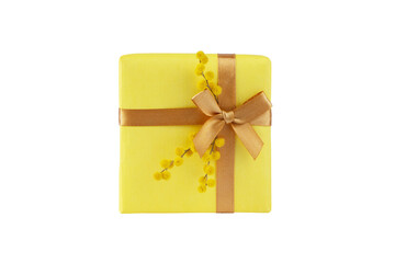 Yellow gift box with golden ribbon bow and mimosa fluffy flowers top view isolated transparent png....