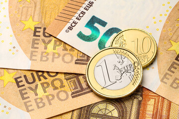 Euro coins on the red fifty paper bills.