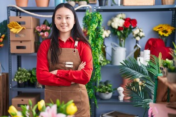 Young chinese woman florist smiling confident standing with arms crossed gesture at flower shop