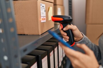 Young blonde woman ecommerce business worker scanning packages using barcode reader at office