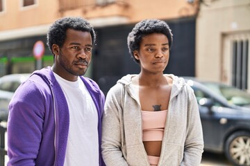 African american man and woman couple standing with relaxed expression at street