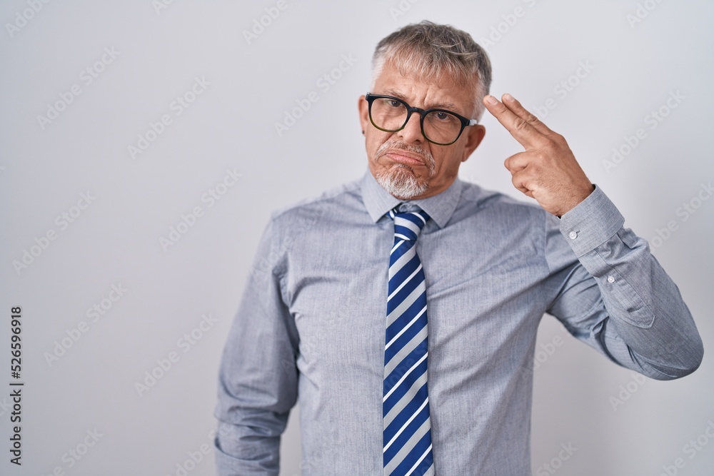 Sticker Hispanic business man with grey hair wearing glasses shooting and killing oneself pointing hand and fingers to head like gun, suicide gesture.