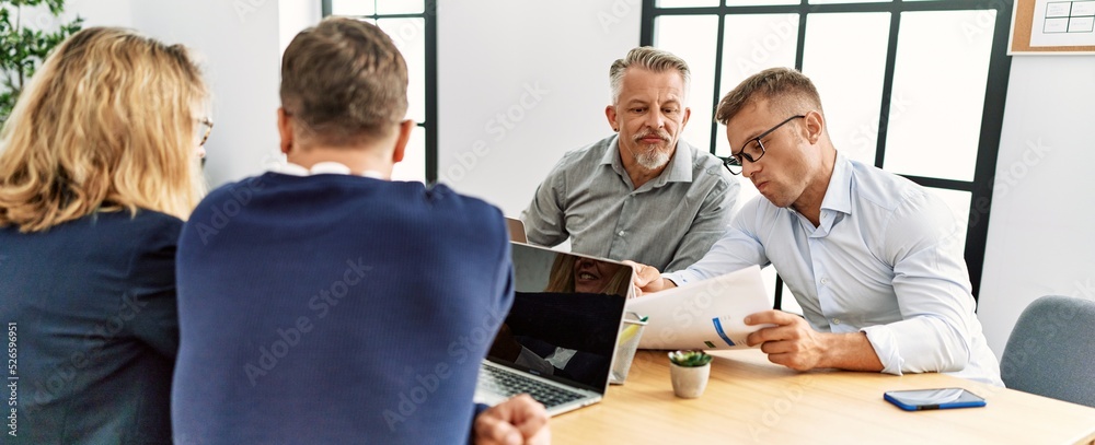 Wall mural Group of middle age business workers working at the office.