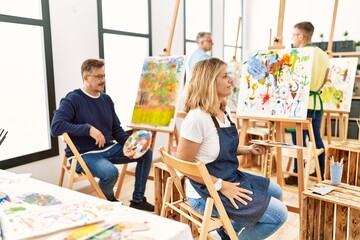 Group of middle age artist at art studio looking to side, relax profile pose with natural face and confident smile.