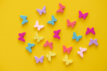 Colored figures in the form of butterfly on a yellow background