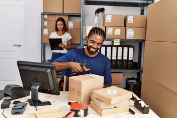 Man and woman business partners scanning package using barcode reader at storehouse