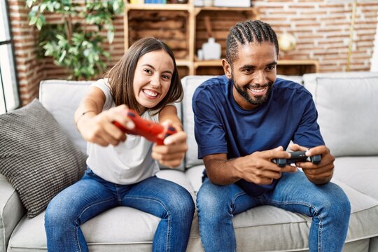 Man and woman couple smiling confident playing video game at home