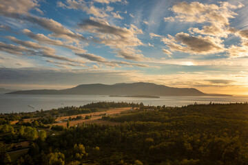 Naklejka na ściany i meble Sunset View of Orcas Island, Washington. A beautiful aerial look at a summer cloudscape over Orcas island in the San Juan Islands and the Salish Sea as seen from Lummi Island.