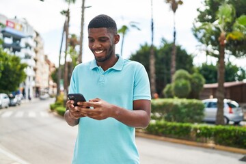 Young african american man smiling confident using smartphone at park