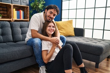 Obraz premium Man and woman smiling confident hugging each other at home