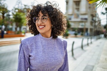 Young middle east woman smiling confident wearing glasses at street