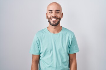 Middle age bald man standing over white background with a happy and cool smile on face. lucky...