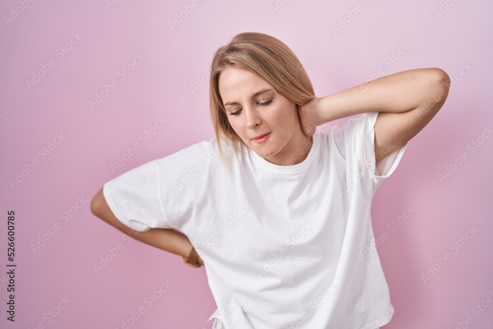 Sticker young caucasian woman standing over pink background suffering of neck ache injury, touching neck wit