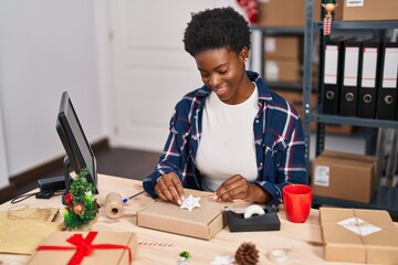 African american woman ecommerce business worker preparing gift at office
