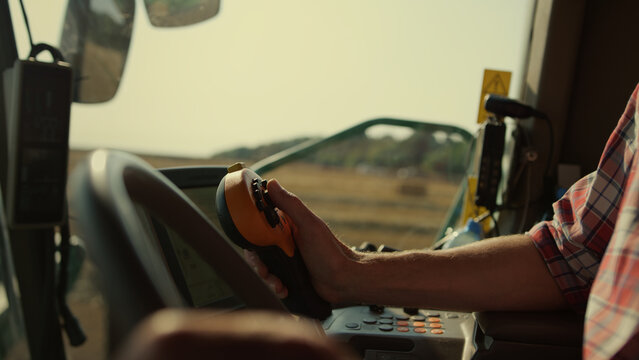 Farmer Hands Driving Harvester Closeup. Tractor Operator Controlling Machinery