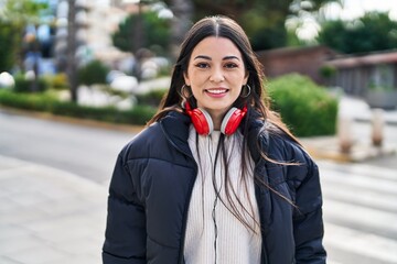 Young beautiful hispanic woman smiling confident wearing headphones at street