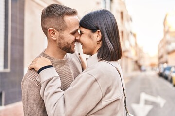 Man and woman couple smiling confident hugging each other standing at street