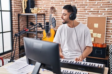 Young arab man musician playing piano keyboard at music studio