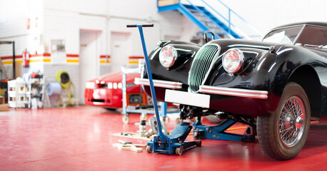 Panoramic view of the interior of a garage. Classic car being repaired. Space for text.