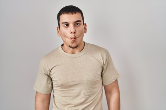 Young arab man wearing casual t shirt making fish face with lips, crazy and comical gesture. funny expression.