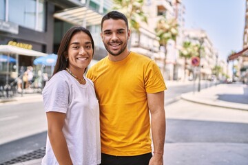 Young latin couple smiling happy and hugging standing at the city.