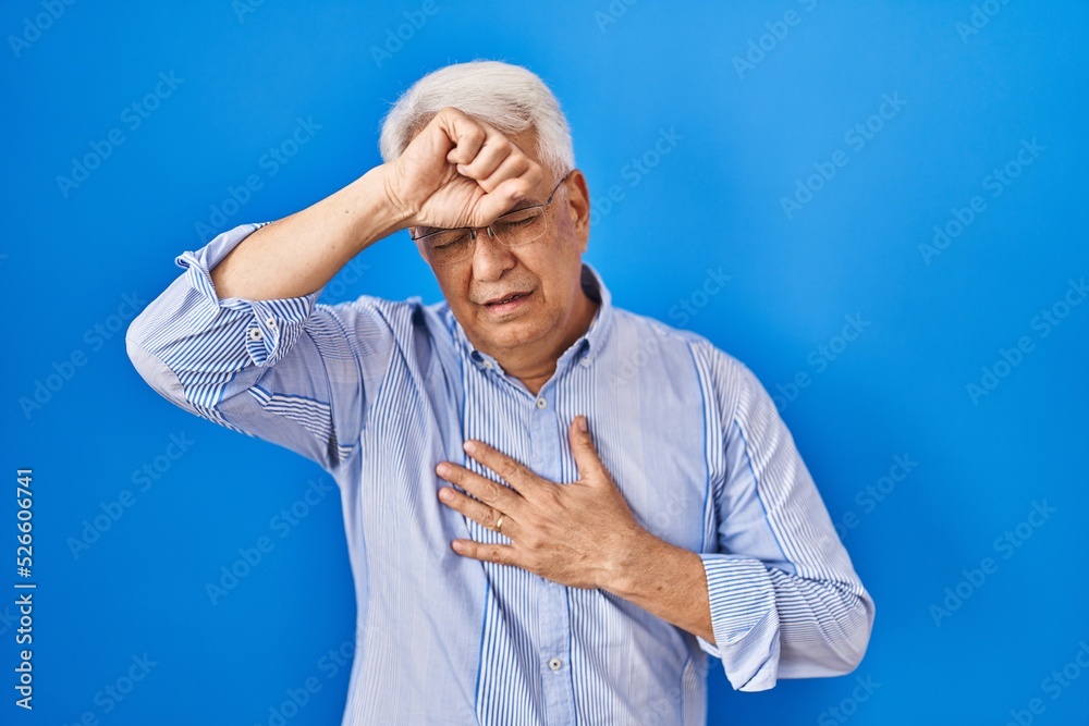 Wall mural Hispanic senior man wearing glasses touching forehead for illness and fever, flu and cold, virus sick