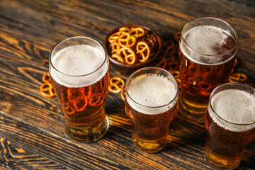Mugs of beer and pretzels on wooden background. Oktoberfest celebration
