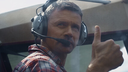 Pilot showing thumbs up sitting airplane cockpit ready to flight close up.  © stockbusters