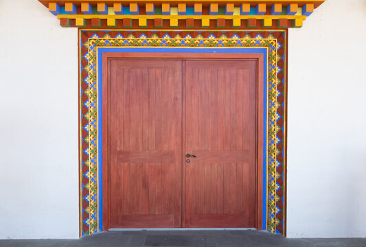porte rouge en bois décorée à l'entrée d'un temple boudhiste