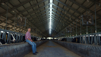 Farm worker resting barn after hardworking day on cowshed. Farmer watching ranch © stockbusters