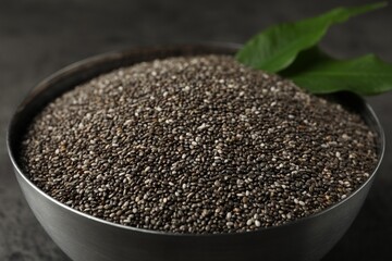 Metal bowl with chia seeds on grey table, closeup