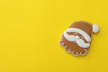 Christmas Santa Claus shaped gingerbread cookie on yellow background, top view. Space for text