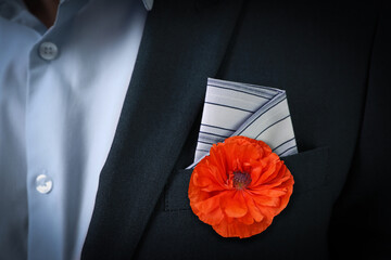 Man with with red poppy flower in suit pocket, closeup view. Remembrance symbol