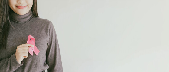 Young Asian woman with pink ribbon, breast cancer awareness, October pink concept, world cancer day