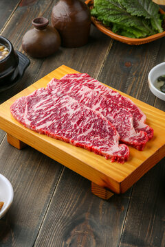 Beef chuck flap tail and side dishes in the background 나무배경에 소고기 살치살과 밑반찬들