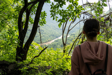 young woman descending in the ravine, vegetation and trees, huentitan ravine guadalajara, mexico