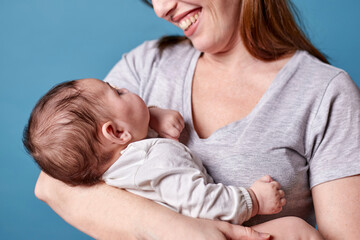 Closeup of woman holding newborn baby in her arms. Maternity, family and love concept.
