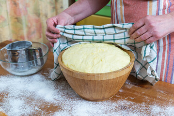 hostess opens the risen dough. Dough that has doubled in size, dough that has risen, proofed dough...