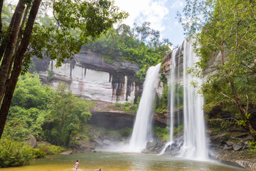 Waterfall in the deep forest. Huai Luang waterfall Huai Luang waterfall middle of the humid forest at Ubon Ratchathani, Thailand, Asia. Leaf moving low-speed shutter blur.